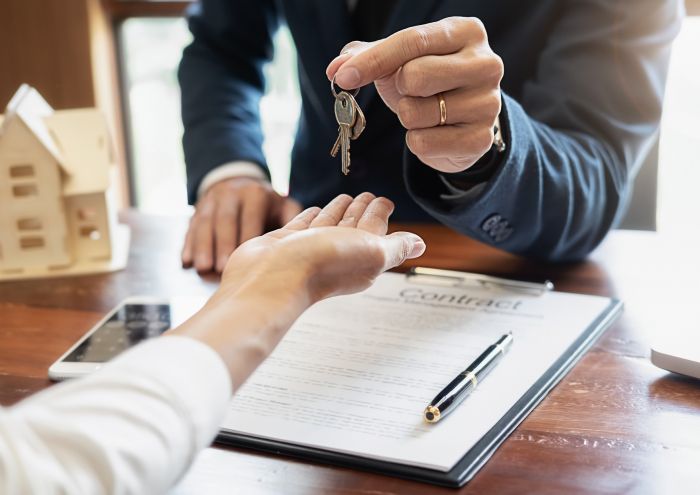 Ein Mann übergibt einen Schlüssel